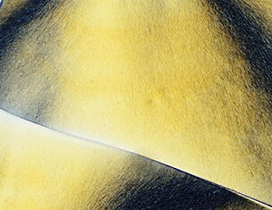 Close-up of smooth, textured surface with rich yellow and dark shadow patterns, creating an abstract appearance.