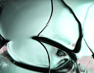 Close-up of swirling glass shapes with smooth, translucent surfaces and contrasting dark lines.