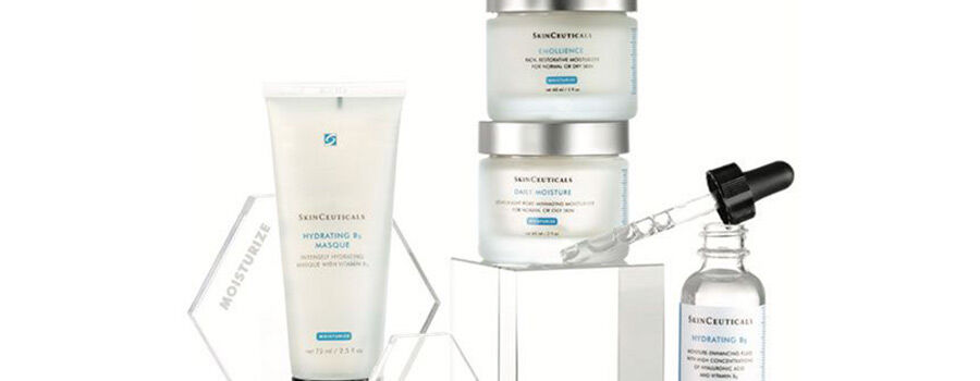 A collection of Skinceuticals skincare products, including a hydrating mask and serums, displayed on a geometric stand.