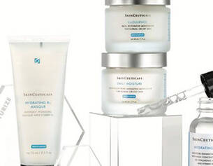 A collection of Skinceuticals skincare products, including a hydrating mask and serums, displayed on a geometric stand.