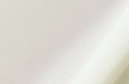 Abstract image featuring soft, light-colored textures with gentle curves and folds.