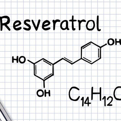 Diagram of the molecular structure of Resveratrol, labeled with its chemical formula C14H12O3, alongside a pen on a notepad with grid lines.