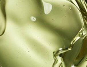Close-up of olive oil, showcasing its smooth, golden-green texture and light refractions.
