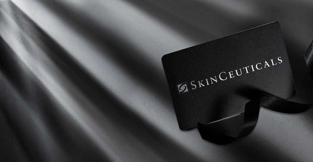 A sleek black gift card for SkinCeuticals placed on a dark, textured background with soft light creating a dramatic effect.