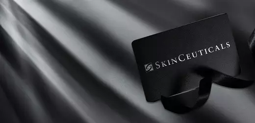 A sleek black gift card for SkinCeuticals placed on a dark, textured background with soft light creating a dramatic effect.