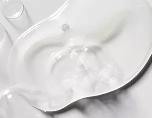 Clear gel forming a smooth, reflective surface, highlighting its fluid texture and subtle contours.
