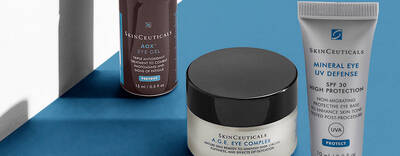 Three skincare products from SkinCeuticals displayed against a blue background: AOX Eye Gel, A.G.E. Eye Complex, and Mineral Eye UV Defense SPF 30.