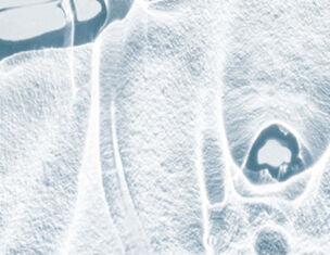 Abstract close-up of a textured icy surface, highlighting intricate patterns and shapes formed by frost and ice.