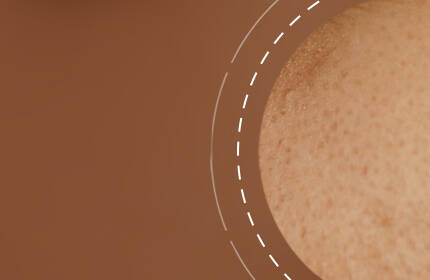 Close-up of a textured brown surface with a circular border, highlighting skin-like features.