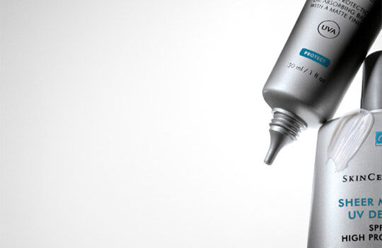 Two skincare products from SkinCeuticals are shown against a gradient background, highlighting their sleek packaging.