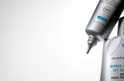 Two skincare products from SkinCeuticals are shown against a gradient background, highlighting their sleek packaging.