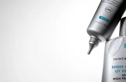 Two SkinCeuticals skincare products are shown against a gradient background, highlighting their sleek packaging design.