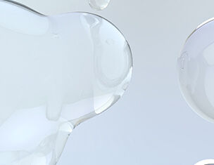 Abstract close-up of translucent gel blobs against a light background, showcasing smooth textures and reflections.