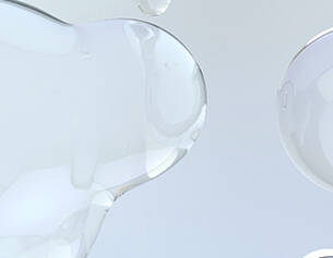 Abstract close-up of translucent gel blobs against a light background, showcasing smooth textures and reflections.
