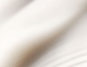 Close-up of smooth, cream-coloured fabric with soft folds and gentle curves, suggesting a sense of elegance.