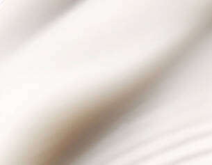 Close-up of smooth, cream-coloured fabric with soft folds and gentle curves, suggesting a sense of elegance.