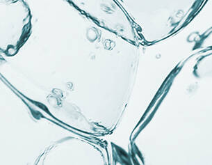 Close-up of ice cubes and bubbles submerged in clear water, creating a refreshing and cool appearance.