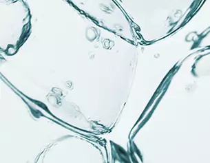 Close-up of ice cubes and bubbles submerged in clear water, creating a refreshing and cool appearance.