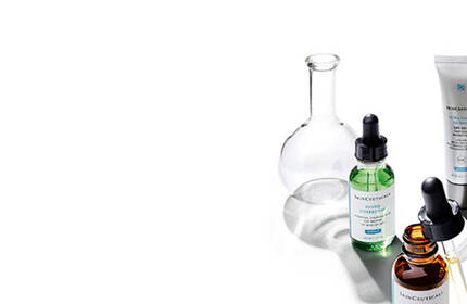 Alt text: A collection of glass vials and droppers containing various colored liquids, arranged on a white background.