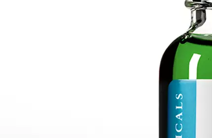 A green glass bottle of SkinCeuticals product sits against a gradient background, showcasing its label and the vibrant liquid inside.
