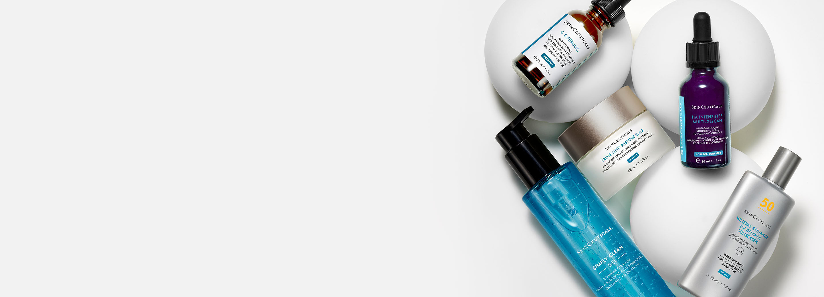 A collection of skincare products, including serums, moisturizers, and sunscreen, arranged on a light background.