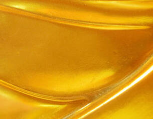 Close-up of a smooth, golden surface with flowing curves, reflecting light and emphasizing its luminous quality.