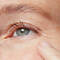 Close up of a mature woman resting a finger on her cheek
