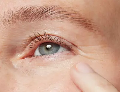 Close up of a mature woman resting a finger on her cheek