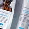 A close-up of two SkinCeuticals products: a brown glass bottle labeled "Phloretin CF" and a tube labeled "Brightening UV Defense SPF 30." The products are placed on a light surface, surrounded by small glass dishes.