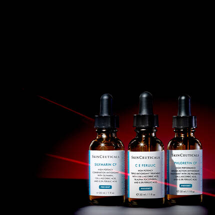 Three dark glass dropper bottles of SkinCeuticals serums, labeled "Silmarin CF," "C E Ferulic," and "Phloretin CF," arranged in a row against a gradient black and red background.
