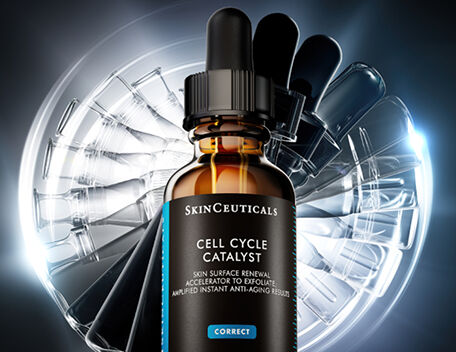 Hand holding H.A. Intensifer serum against a grey background