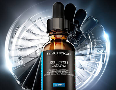 Hand holding H.A. Intensifer serum against a grey background