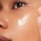 Woman applying SkinCeuticals Retinol 0.3 to her cheek