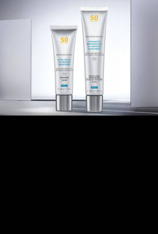 A dropper bottle of SkinCeuticals C E Ferulic serum is lit against a dark background, accompanied by a pair of glasses. The setting features abstract lines and a misty atmosphere.