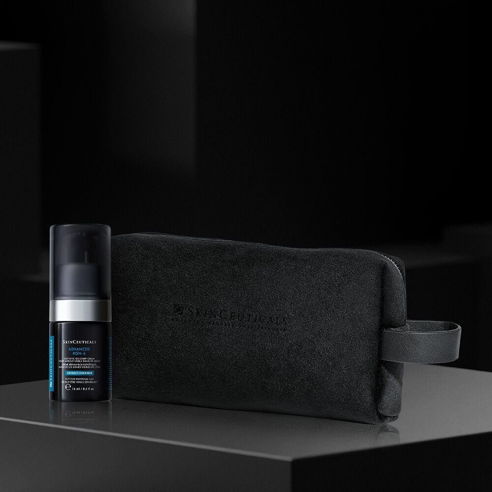 A bottle of SkinCeuticals C E Ferulic serum is featured against a dark background, with dynamic red and gray abstract shapes surrounding it, highlighting its 20-year anniversary.