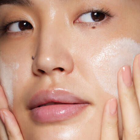 Close-up of sunscreen being applied to the under-eye area for daily sun protection