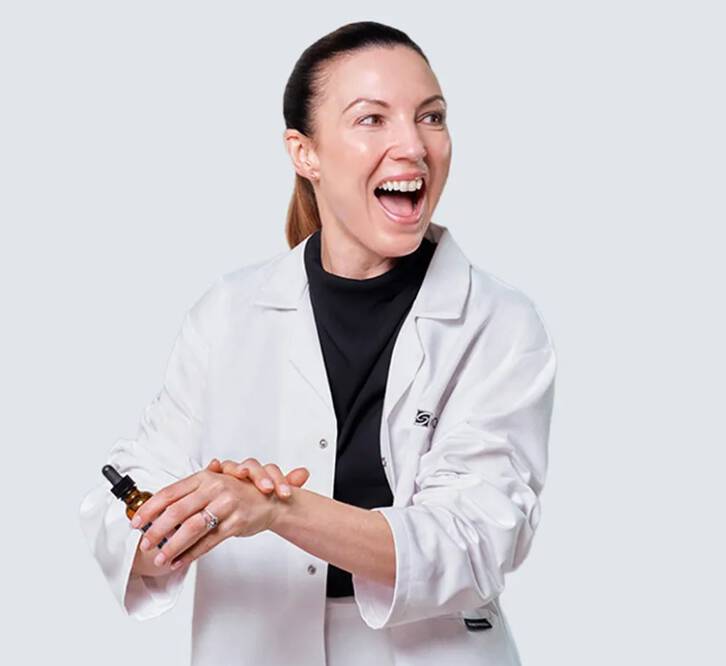 Consultant Dermatologist Dr Emma Craythorne holding a SkinCeuticals vitamin C serum”.
