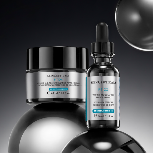 A close-up of beauty products displayed on a sleek, modern shelf, featuring various serums and oils in elegant bottles, set against a dark background.