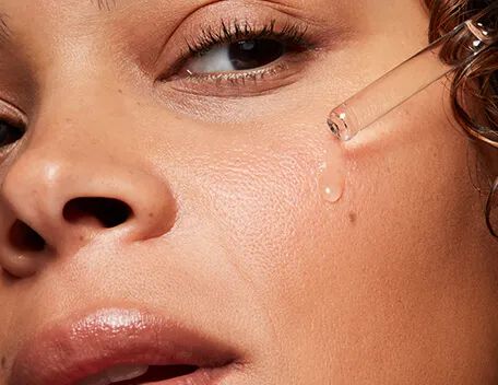 Woman applying a SkinCeuticals hydrating serum to her cheek