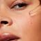 Woman applying a SkinCeuticals hydrating serum to her cheek