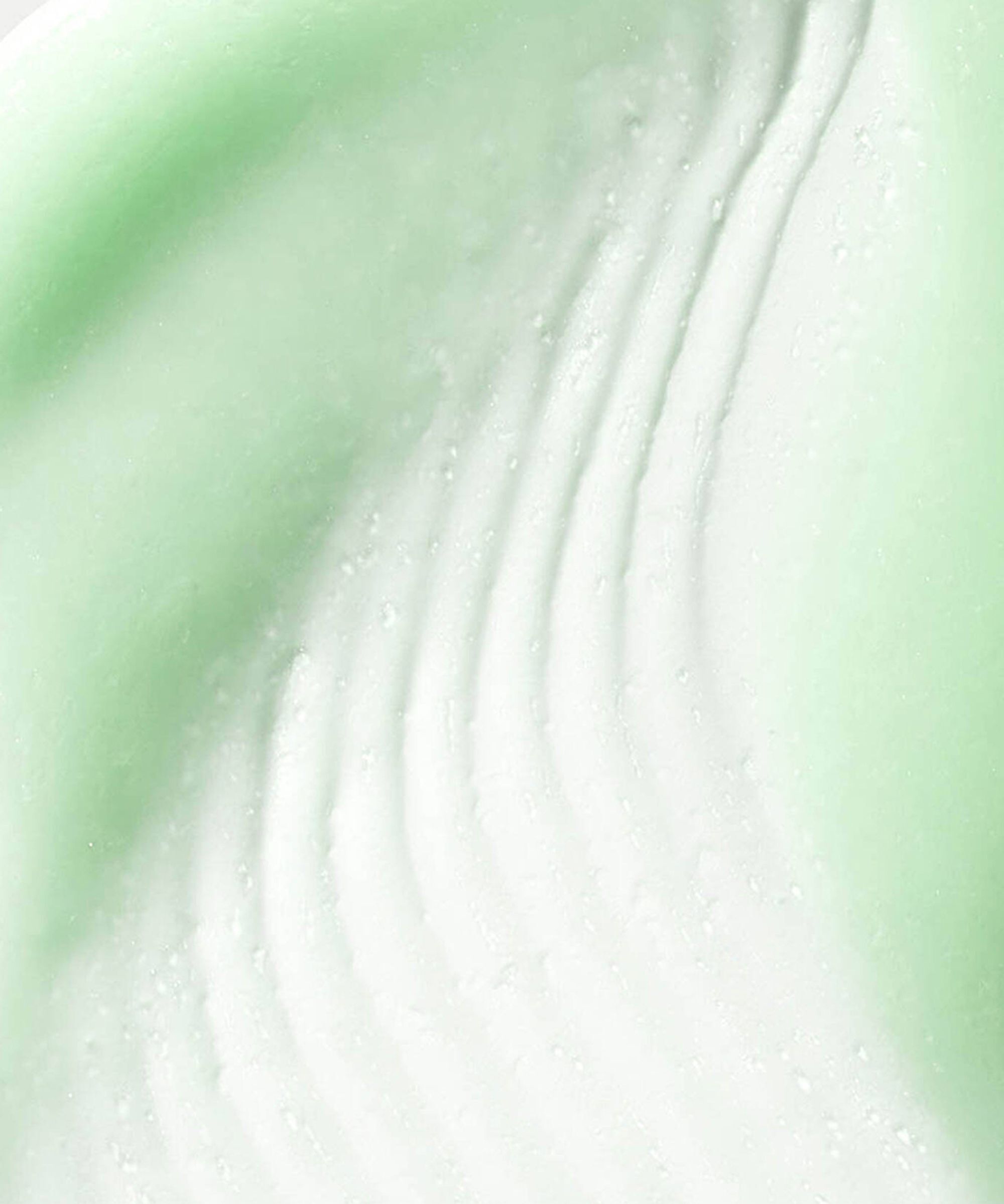 Close up texture shot of Phyto A+ Brightening Treatment – a pale green moisturiser with a raked effect running through