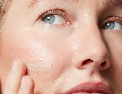 A flat lay of various skincare products arranged on a light background, including serums, a moisturizer, and a sunscreen bottle.