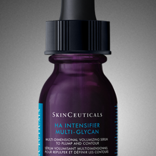 A bottle of SkinCeuticals C E Ferulic serum is featured against a dark background, with dynamic red and gray abstract shapes surrounding it, highlighting its 20-year anniversary.